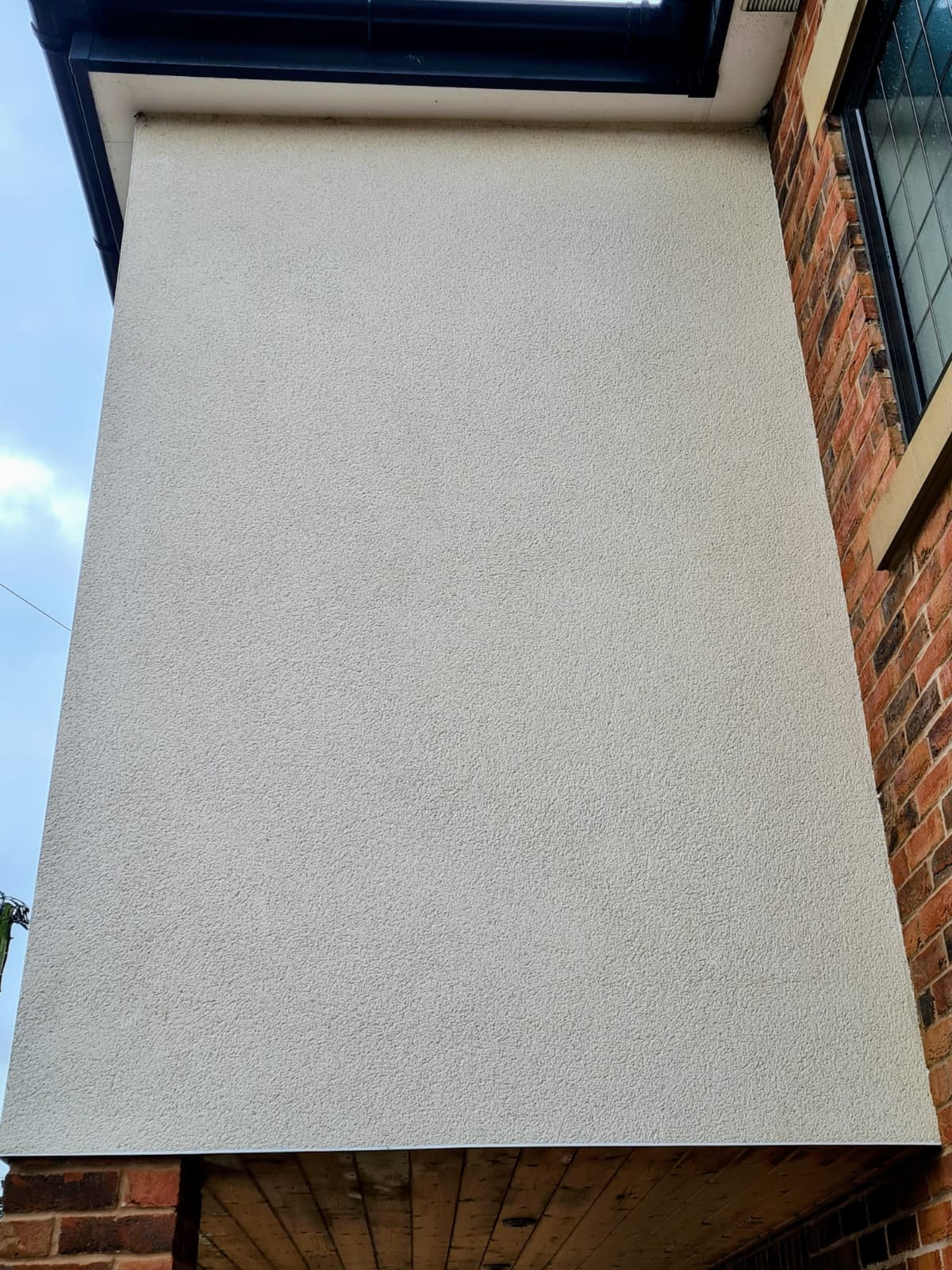 Render cleaning East Cheshire — clean white render restored on bay window using soft wash technique